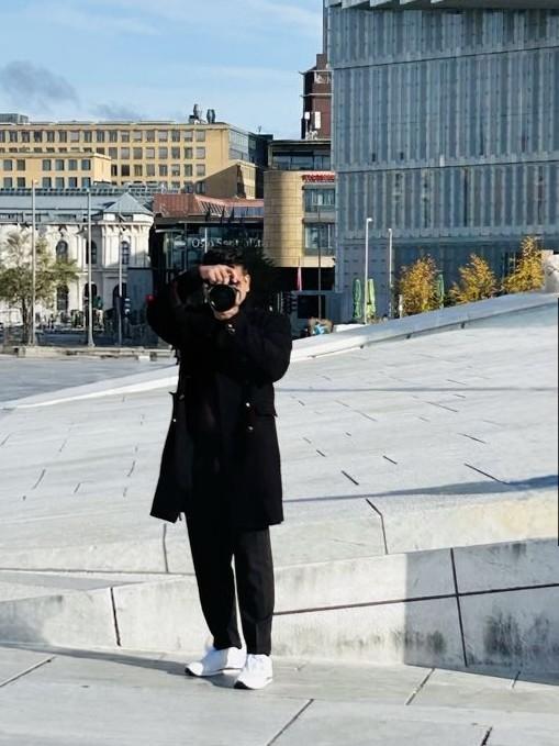 Raising a camera on the sloped marble of the Oslo waterfront, with the city and Oslo S behind