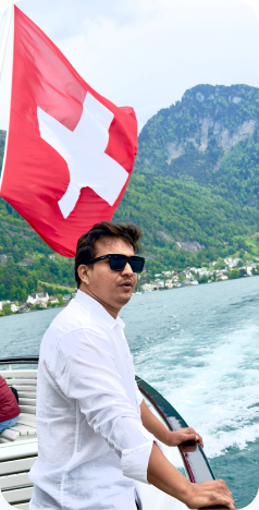 At the railing of a boat under a Swiss flag on a lake