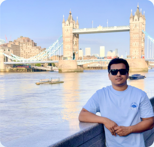 Leaning on a riverside wall in front of Tower Bridge, London